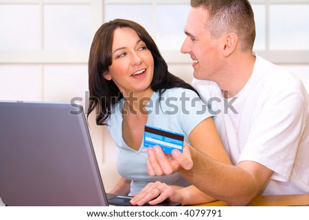Happy couple paying with credit card