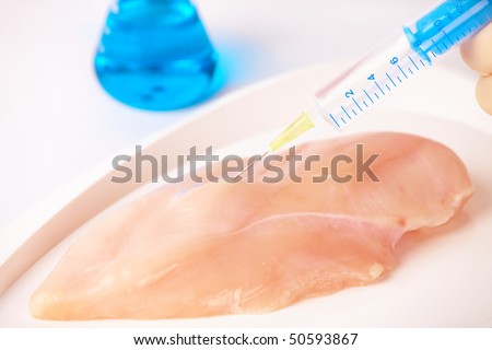 Researcher injecting GMO chicken meat. Genetically modified organism or GEO here transgenic plant is an plant whose genetic material has been altered using genetic engineering techniques