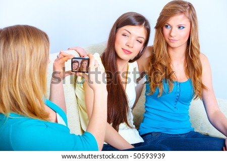 Three young girls taking photos on the meeting in home.