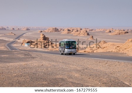 DUNHUANG,CHINA-OCTOBER 17:The tourist bus in the Yadan landforms on October 17,2013 in Dunhuang ,Gansu,China.Yadan Landforms is physiognomy landscape formed by Aeolian cover 400 square kilometers.