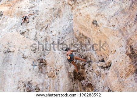 Krabi,Thailand - March 29, 2014: Rock climbers climbing on Railay beach in Krabi, Thailand. Railay beach is one of the most popular rock climbing locations in Asia.