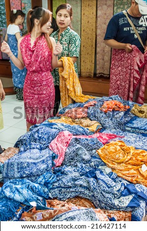 Bali, Indonesia, April 21,2010 : Tourist choose and try on Batik cloth at culture shop in Bali,Indonesia.Batik-making is an important part of Indonesian culture.