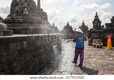 Yogyakarta,Indonesia - April 27,2010 : Worker cleaning the wall of   Borobudur Temple at morning  in Yogyakarta Java Indonesia. Borobudur Temple is one of the most visited temple in Indonesia.