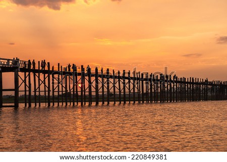 Mandalay,Myanmar-March 16,2011 : Unidentified Myanmar  People  on U-Bein bridge in sunset in Mandalay, Myanmar. The U-Bein bridge is the longest teak bridge in the world, 1.2km lenght .
