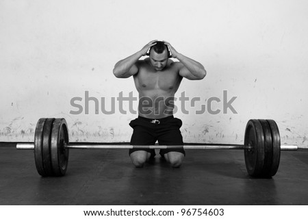An athlete is preparing to lift a heavy dumbbell