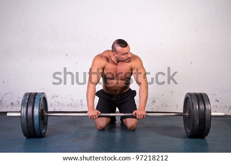 Man preparing to lift a heavy dumbbell