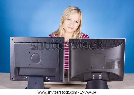 young blonde woman at the two computer\'s screens (blue background)