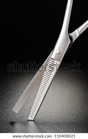 Professional hairdressing scissors on a black matt background