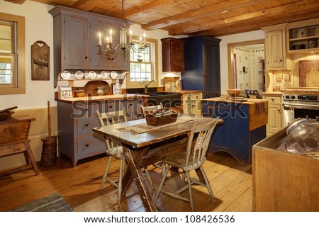 The kitchen in a primitive colonial style reproduction home, built with materials reclaimed from structures built in the late 1700\'s.  The room contains many antiques from the late 18th century.