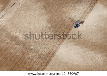 An aerial view of a tractor plowing a field