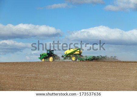 Rexburg, Idaho, USA  Apr. 22, 2013 Farm machinery planting wheat on a windy spring morning.