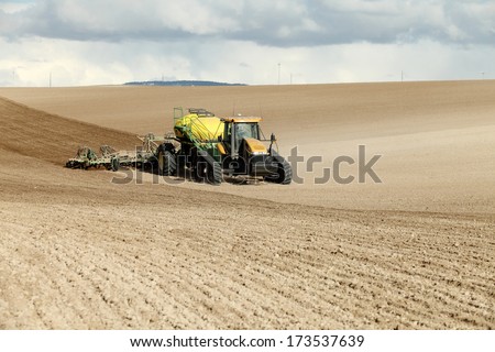 Rexburg, Idaho, USA Apr. 22, 2013  Farm machinery planting rows of wheat on a windy spring day in the fertile farm fields of Idaho.