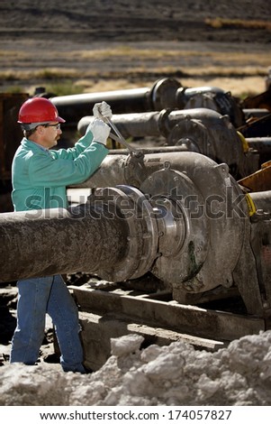 POCATELLO, IDAHO USA  SEPT 26, 2009 A laborer performs maintenance on an industrial pipeline pumping station.