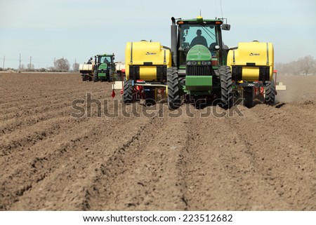 Fort Hall, ID USA, Apr. 12, 2013 Two tractors in the field planting potatoes