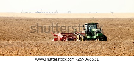 Rexburg, Idaho, USA Oct. 9, 2012- Farmers using farm machinery in the field harvesting potatoes.  The potatoes are dug, gently placed on top of undug rows of potatoes.