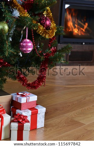 Christmas tree and christmas gift boxes in  interior with  fireplace