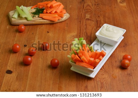 fresh celery sticks, carrot and blue cheese sauce on wooden background