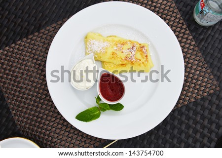 pancakes on dish with sour cream and jam