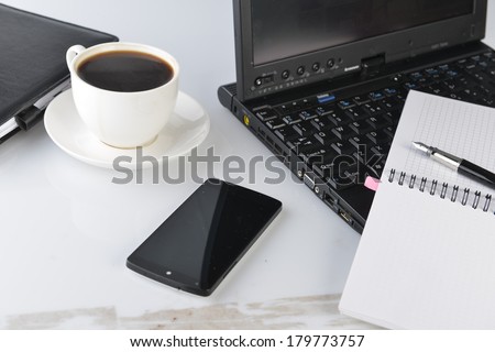 open notebook, mobile  phone,  pen and cup of coffee