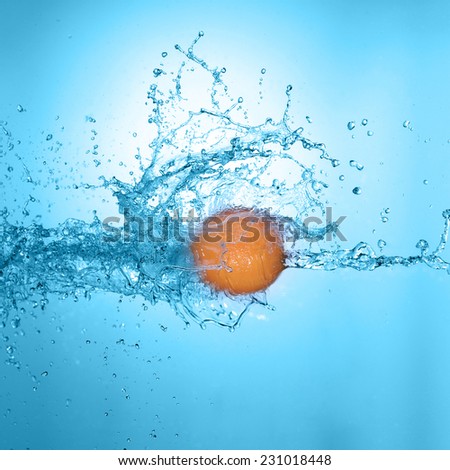 big orange in splash of water isolated