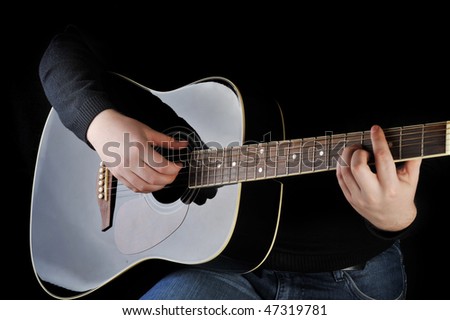 Young man playing on black  guitar.
