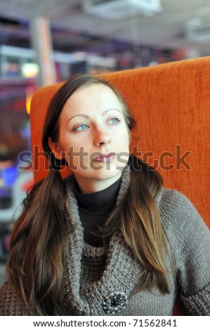 young woman sits on  chair in  restaurant