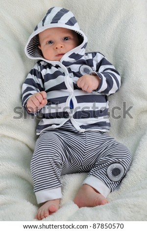 Adorable little  boy in striped blouse on  blanket