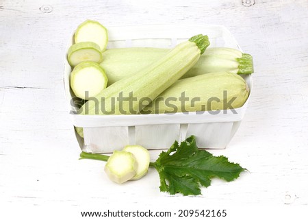 Fresh sliced marrow vegetable in basket. Isolated on white background