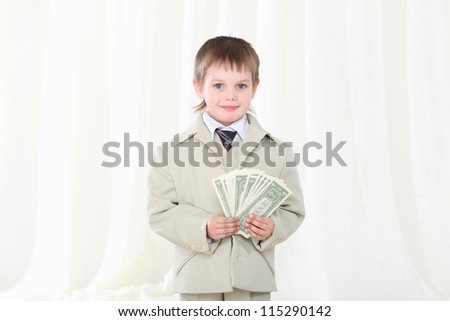 Little smart boy in suit showing dollars