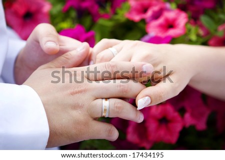 Man and woman wedding hands with the flowers bouquet