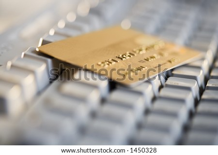 Gold credit card resting on a computer keyboard