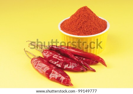 Red chilly pepper , red pepper powder on yellow background