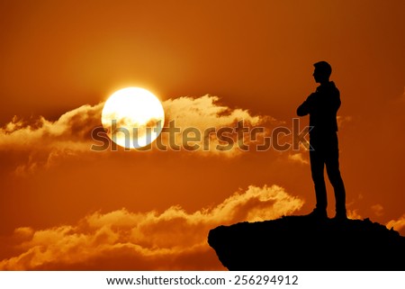Silhouette of man at the top of the mountain on sunset. Beautiful landscape.