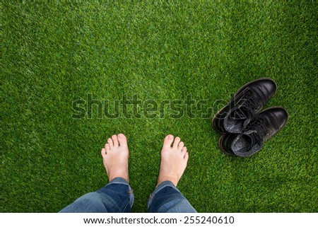Mens feet resting on green grass