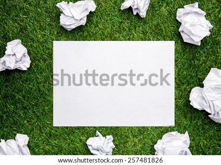 White sheet of paper with cramled sheets on the grass