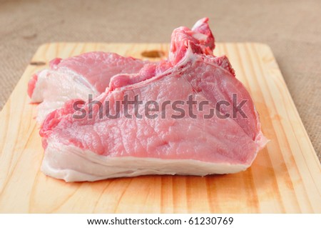 pieces of steak on the bone lying on a wooden board