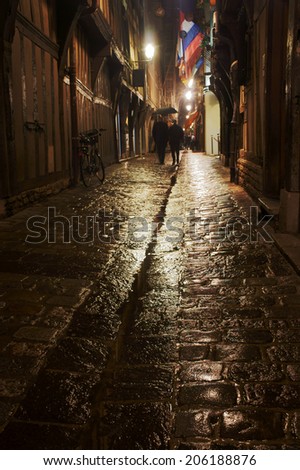 The street and buildings in the rain at night in Troyes, France