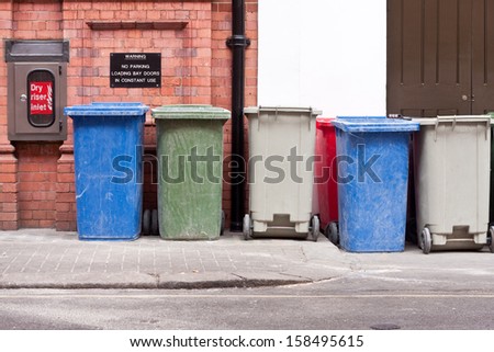 A row of different coloured wheelie bins