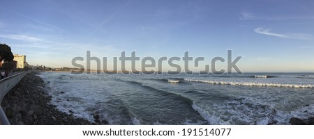 VENTURA, CA - APRIL 23, 2014: Walking people and surfers enjoying cool Pacific ocean breeze and waves near historic wooden pier, City of San Buenaventura, Southern California