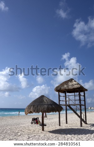 Beach umbrella and Lifeguard watch tower at Caribbean sea coast, Cancun ((La Isla Dorado), Mexico