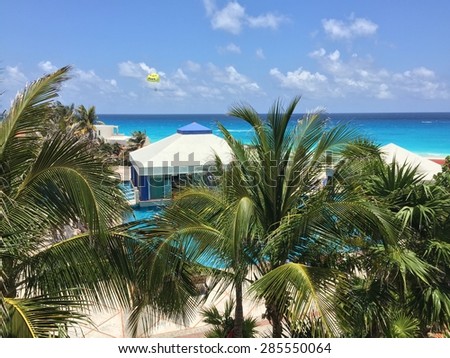 CANCUN, MX - May 17, 2015: Recreational parasailing above Caribbean sea near Cancun\'s Solymar Beach and Resort hotel (La Isla Dorado)