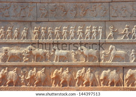 Wall with a carved relief: big ancient Indian army with horses and elephants