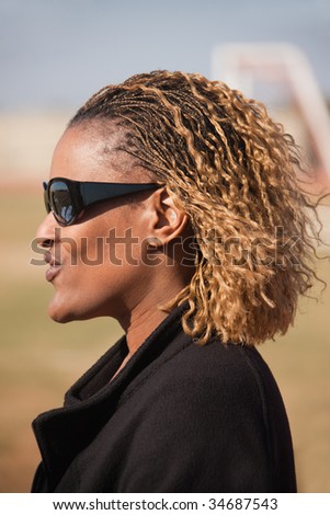 lifestyle portrait of an African middle age woman, outdoors sunny day