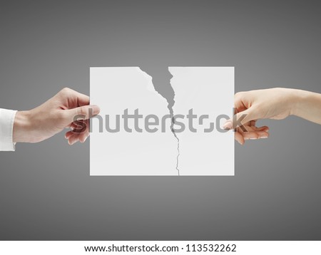 two hands holding a torn sheet of paper