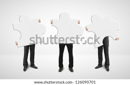 three businessman holding puzzle card