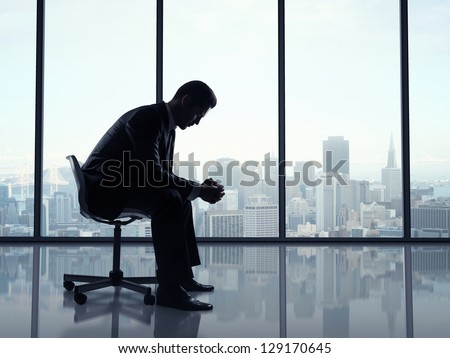 businessman sitting in office and city views in window