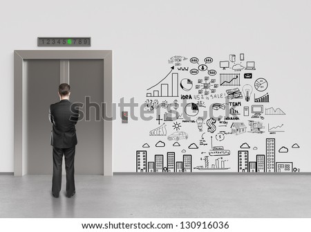 businessman looking at elevator and drawing business plan