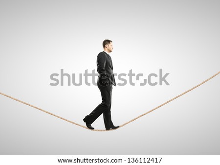 businessman walking on rope on a white background