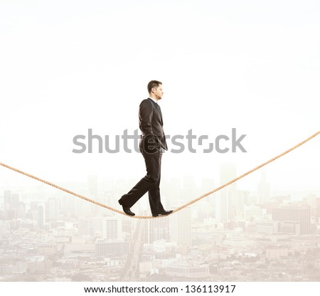 businessman walking on rope and city