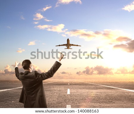 happy businessman standing on runway and looking on airplane